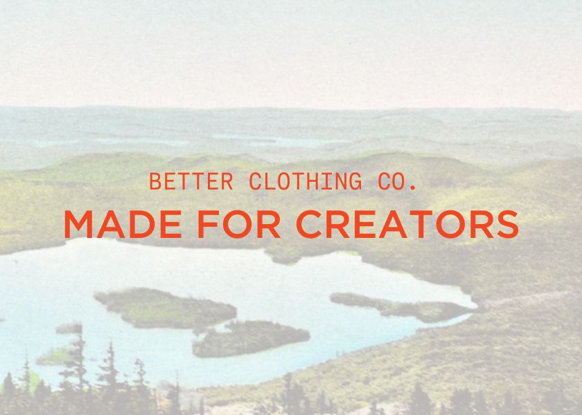 vintage postcard background of lakes and forest with text "better clothing co. made for creators" overlayed on top