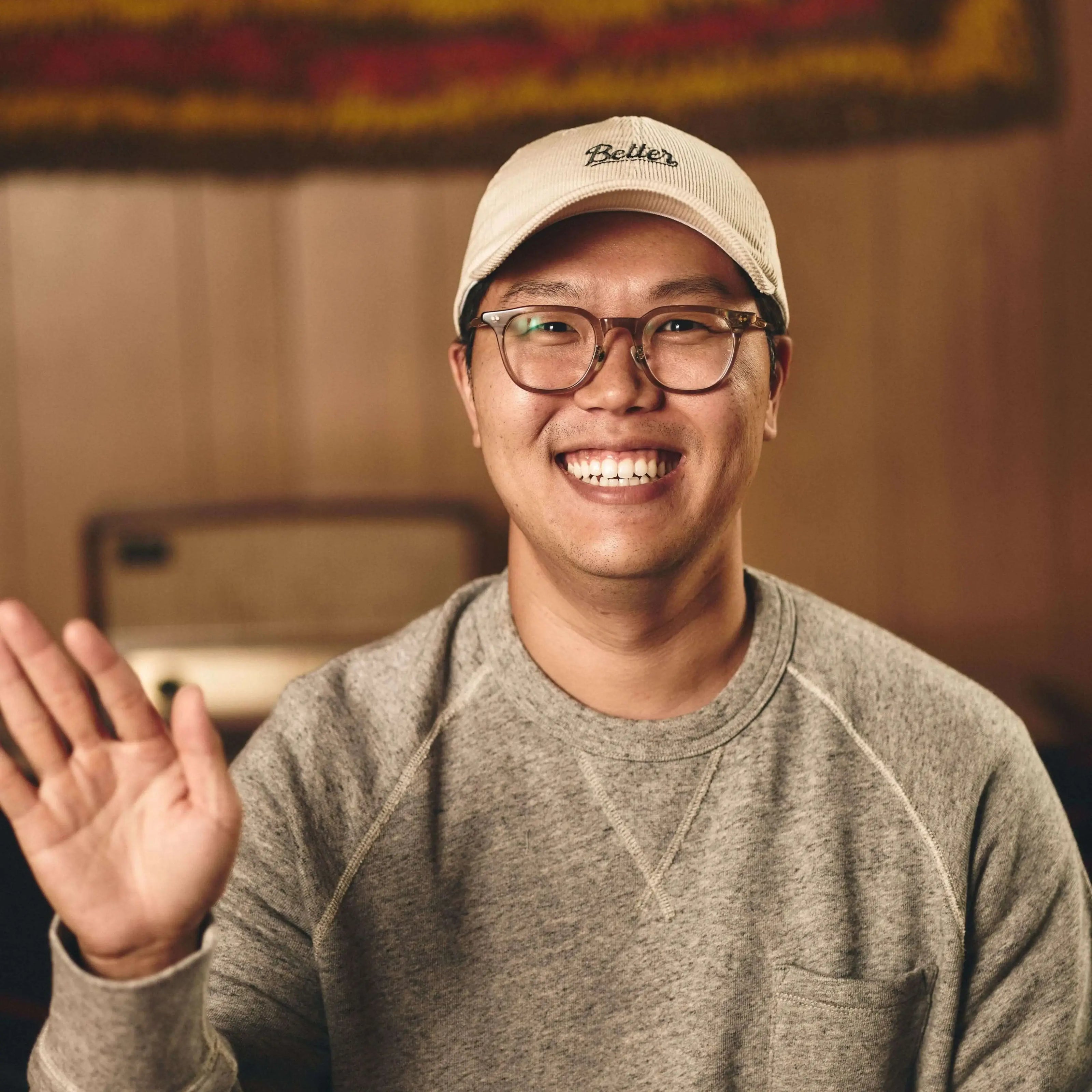 Ho, founder of Better asian man with glasses waving to the camera